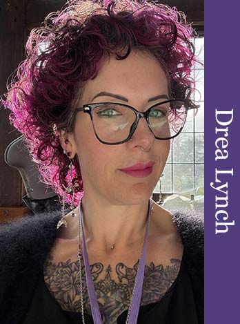 This photo shows a head shot of Drea Lynch, photographed in an elegantly furnished room, looking into the camera. Drea is wearing a black mohair jumper and a lanyard. Drea is smiling enigmatically. There is a purple coloured vertical graphical bar to the right of the photo, with the text